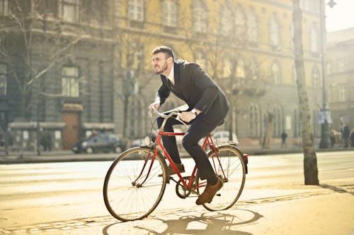 黑色西装的男人骑自行车在街上