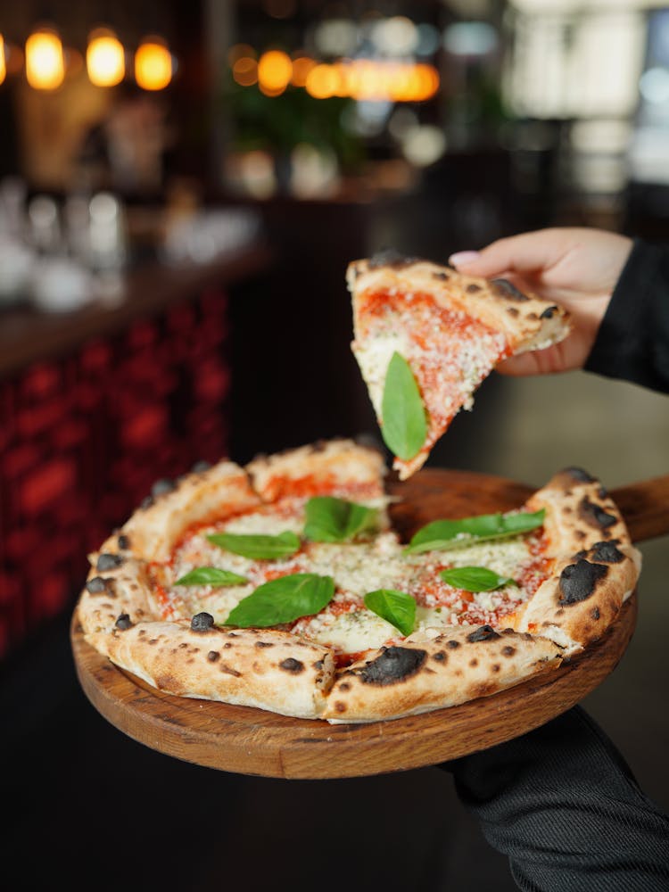 Woman Hand Holding Pizza Slice