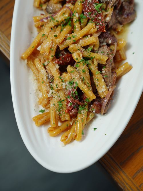 Free Savor the rich flavors of Italian casarecce pasta with succulent lamb, grated cheese, and herbs. Stock Photo