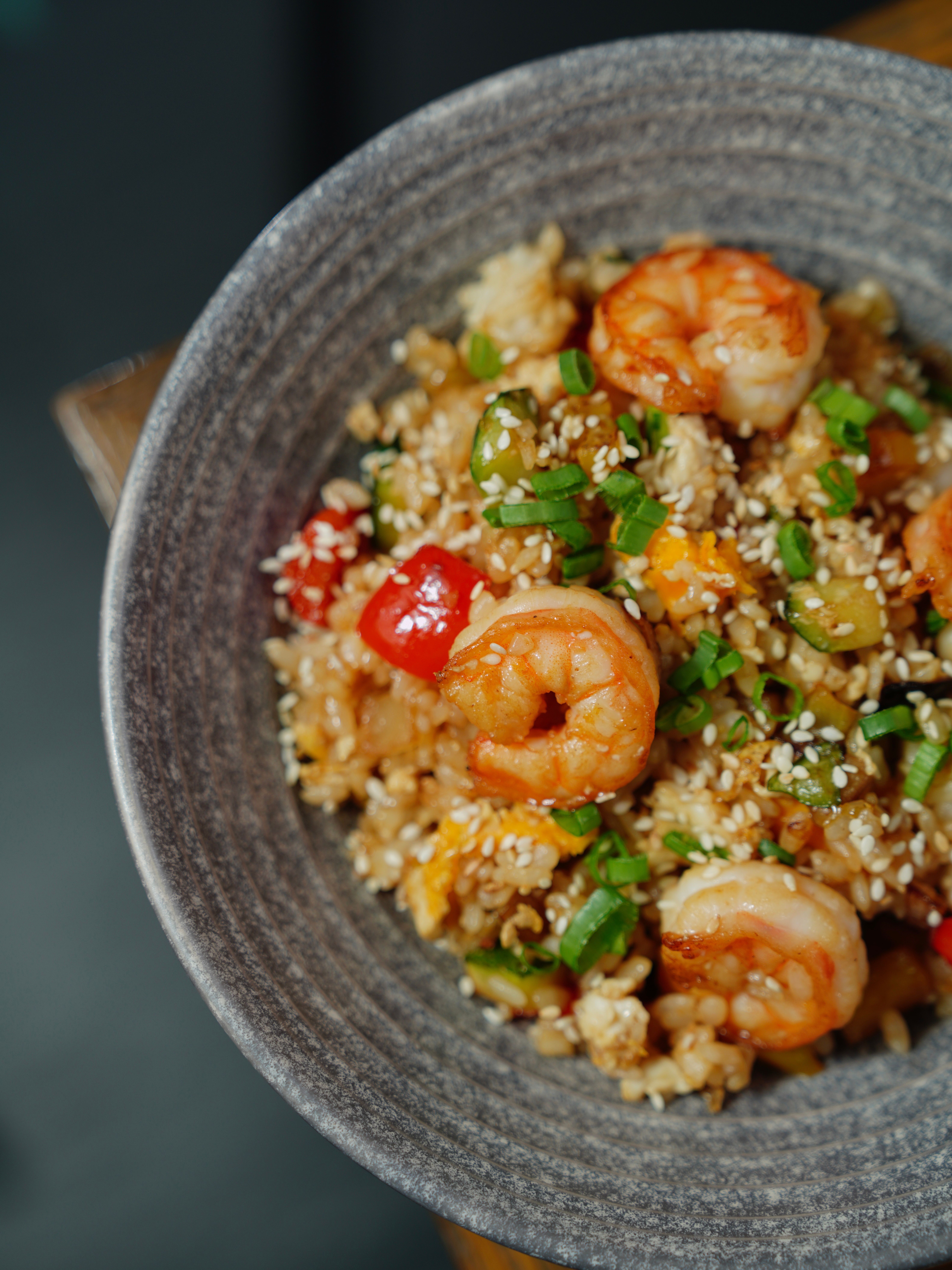 Delicious shrimp and vegetable fried rice garnished with sesame seeds and chives.