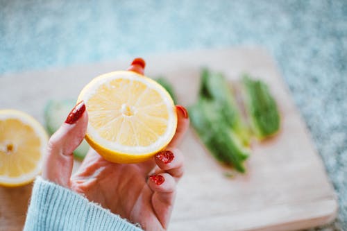 Free Selective Focus Photography of Person Holding Sliced Lemon Stock Photo