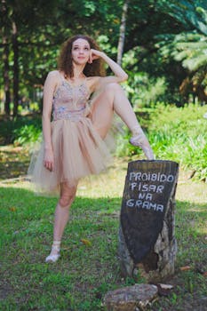 在风景秀丽的公园里，芭蕾舞女演员优雅地在一棵树桩旁摆姿势，旁边立着一块写着“不要在草地上行走”的标志