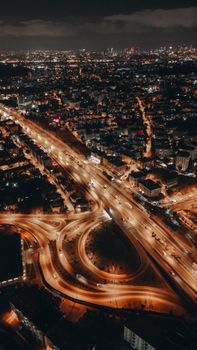A captivating aerial view of an urban cityscape showcasing bright lights and intricate road networks at night.