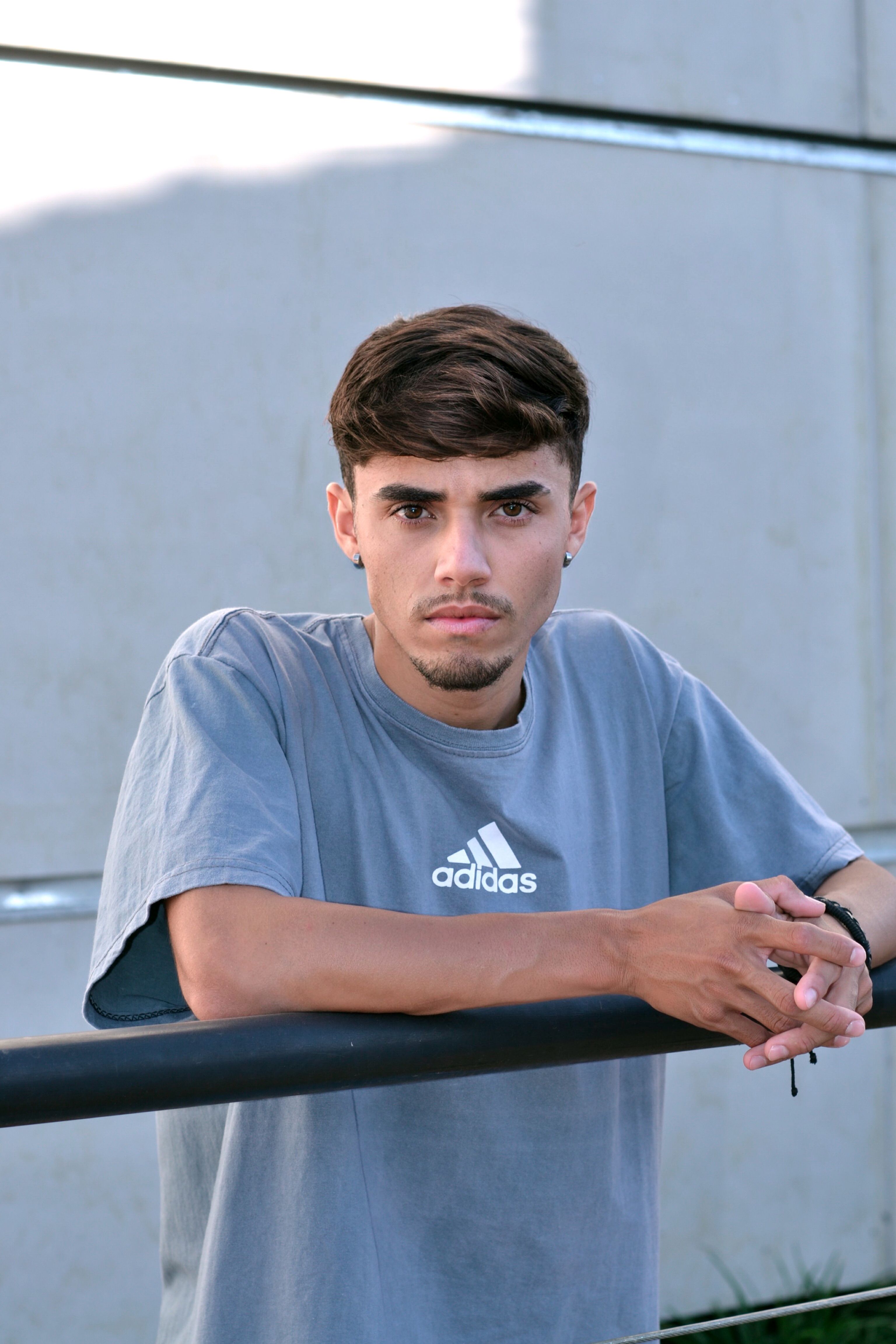 Retrato de um jovem em pé ao ar livre em Sete Lagoas, Brasil, vestindo uma camiseta casual.