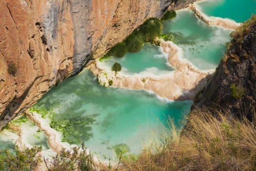 A stunning view of natural lagoons surrounded by rocky cliffs in Ayacucho, Peru.