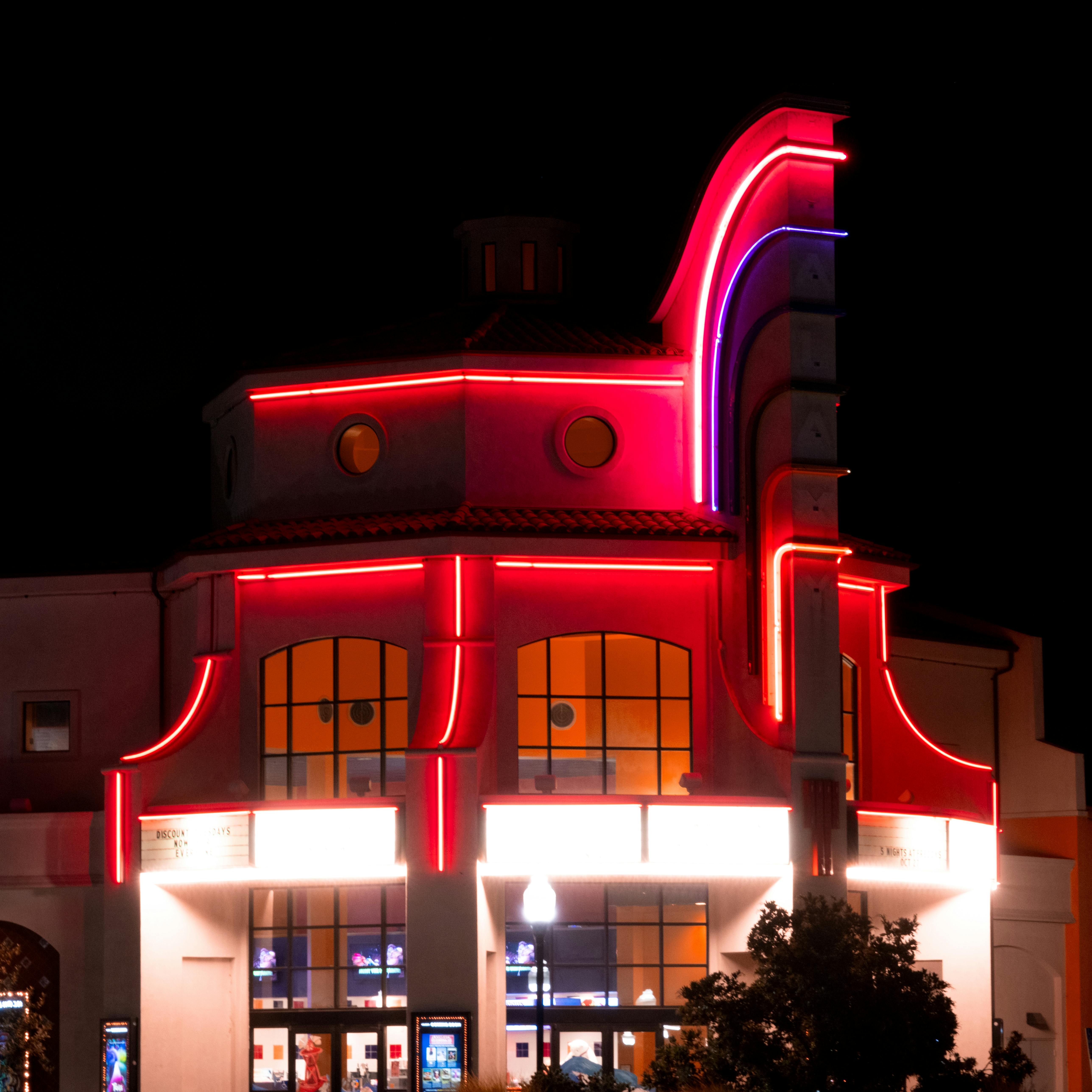 Free Vibrant neon lights illuminate a cinema building in Atascadero, CA at night. Stock Photo