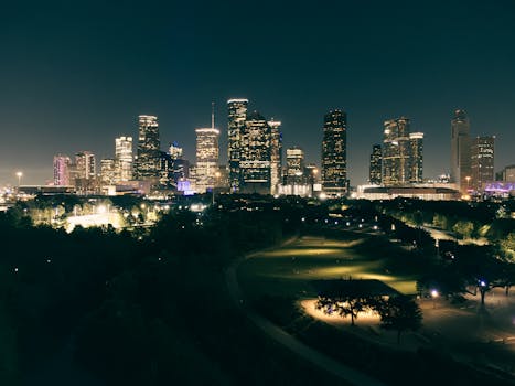 Stunning aerial view of Houston skyscrapers illuminated at night with vibrant city lights.