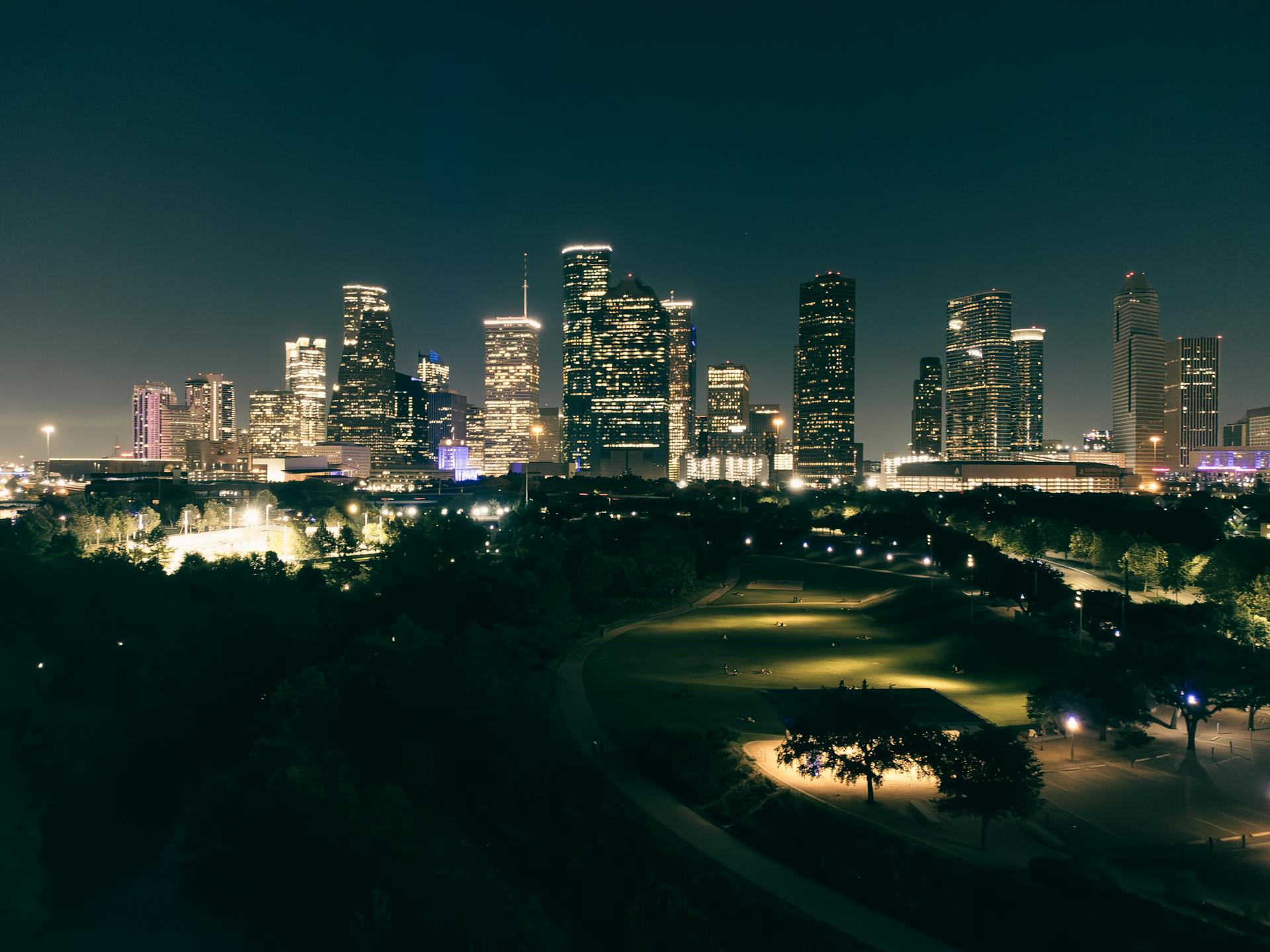 Stunning aerial view of Houston skyscrapers illuminated at night with vibrant city lights.