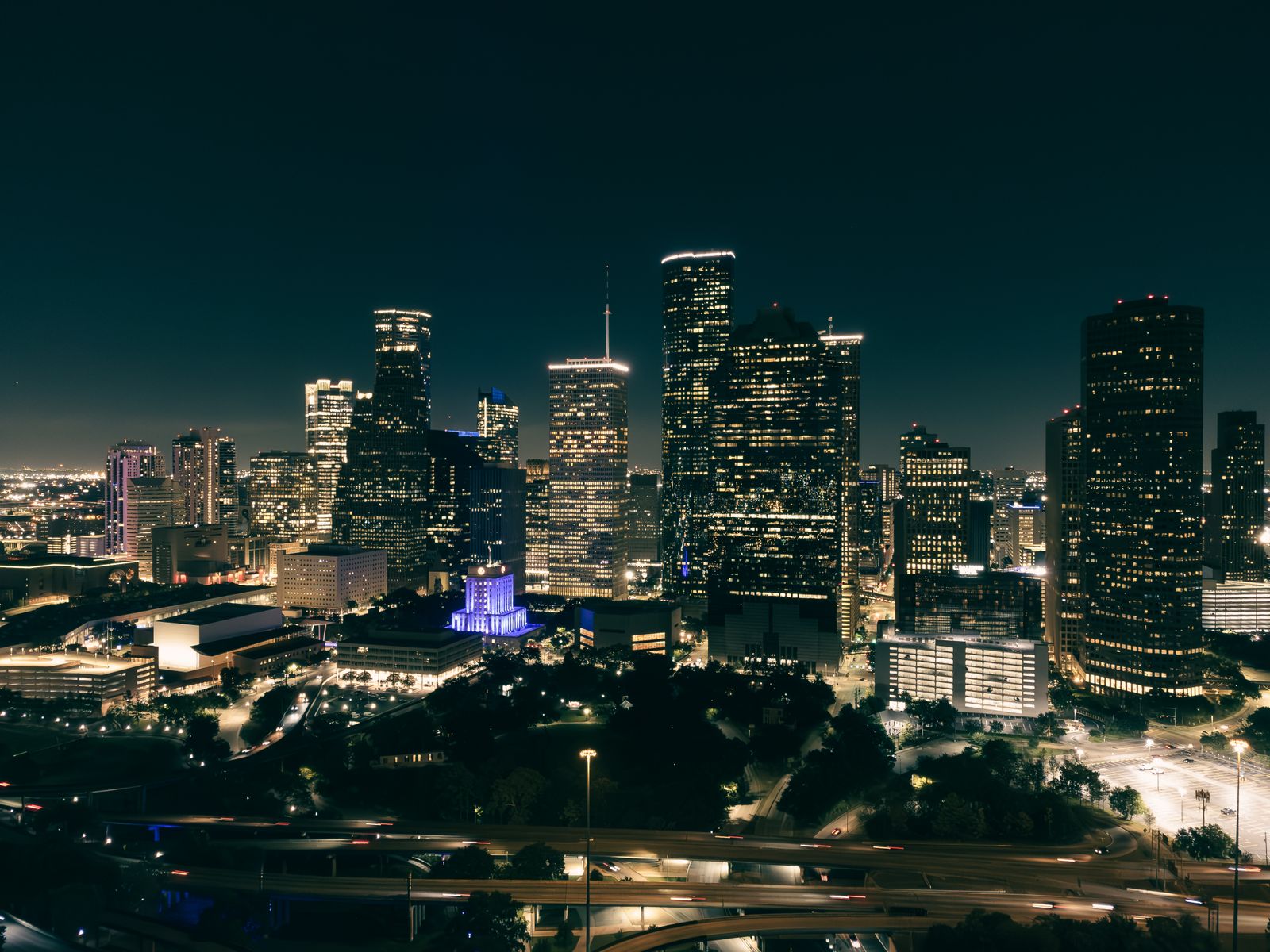 Aerial view of an illuminated downtown skyline at night — photo by Erik Mclean on Pexels