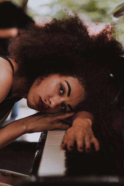 Woman Resting Head on Piano