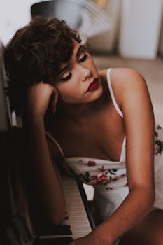 一位涂着红色唇膏的女人靠在钢琴上，显得优雅而沉思