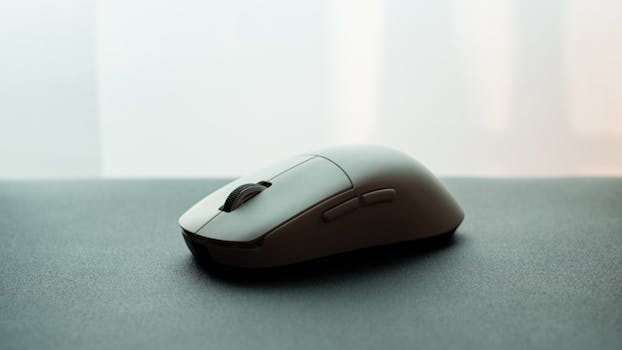 Close-up of a white wireless computer mouse on a dark surface, emphasizing sleek design.