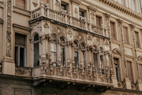 Free Detailed view of a neoclassical building facade featuring ornate balconies and bas reliefs. Stock Photo