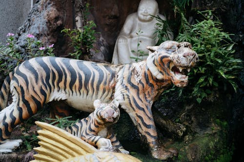 A statue of a tiger and a fish in a garden