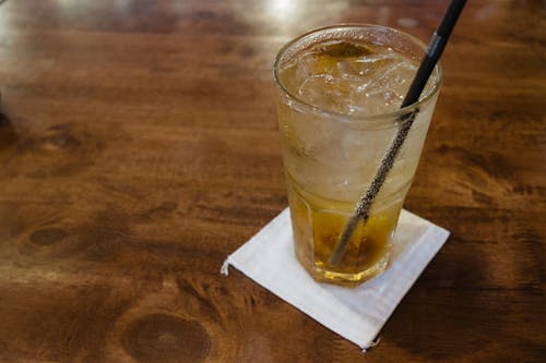 A glass of iced tea with a straw on a wooden table