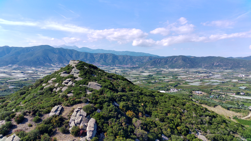 Free A breathtaking view of mountainous terrain with lush greenery and expansive fields. Stock Photo
