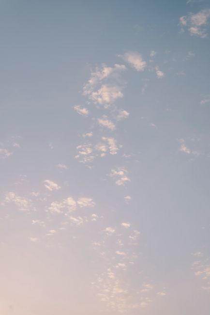 A serene pastel sky featuring soft clouds and a subtle gradient, perfect for calming backgrounds.