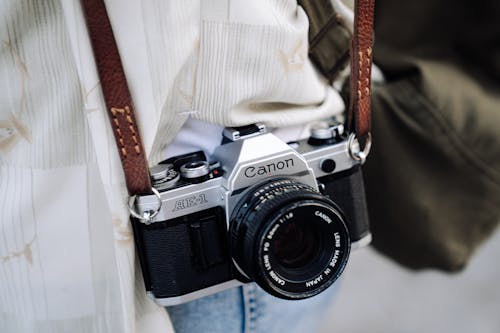 Canon AE-1 Analog Photo Camera Hanging on a Leather Strap