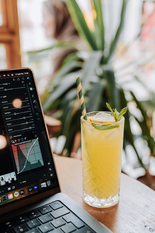 Free Glass with a Drink and a Straw by a Laptop Stock Photo