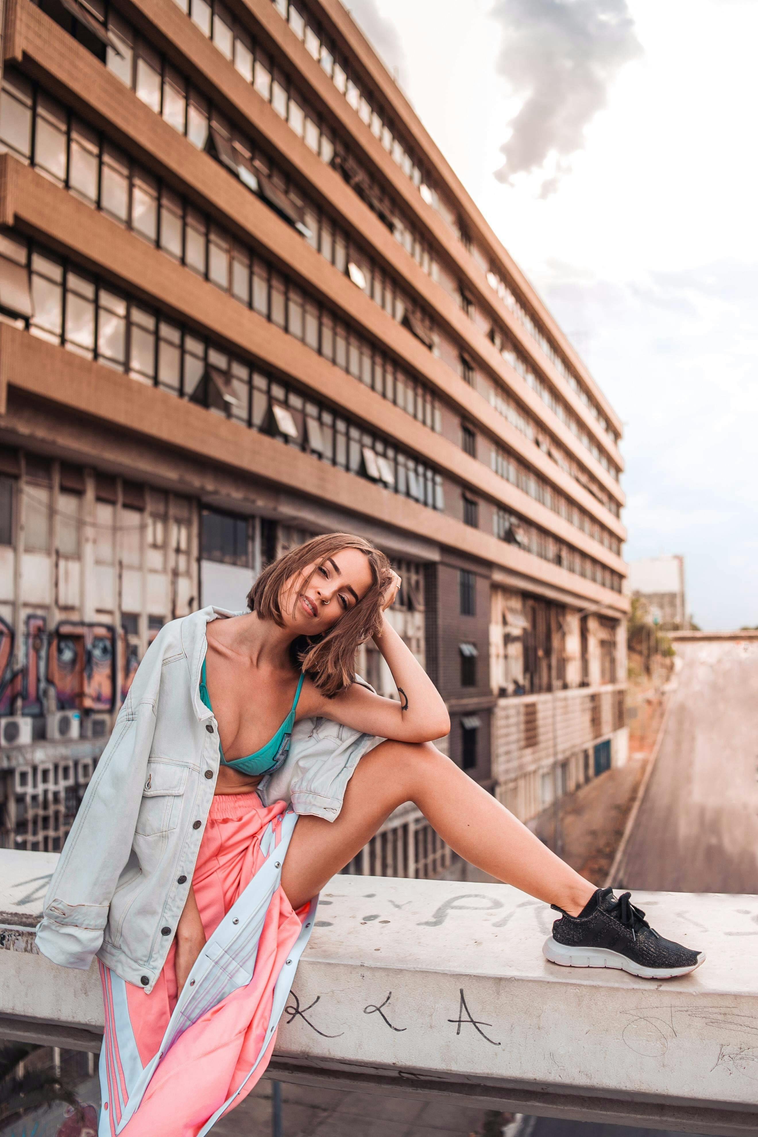 在涂鸦背景的城市环境中，时尚的女人随意摆着姿势