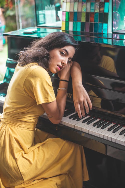 Wanita Bersandar Pada Pose Piano Hitam