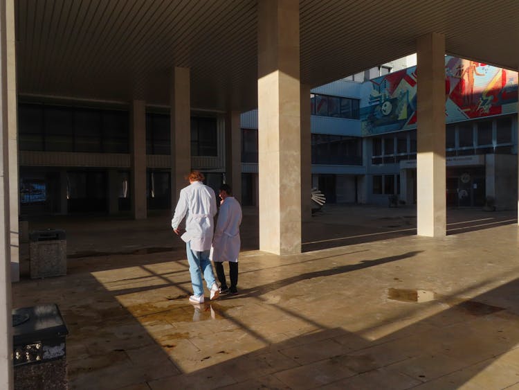 Doctors Walking Through A Hospital Yard