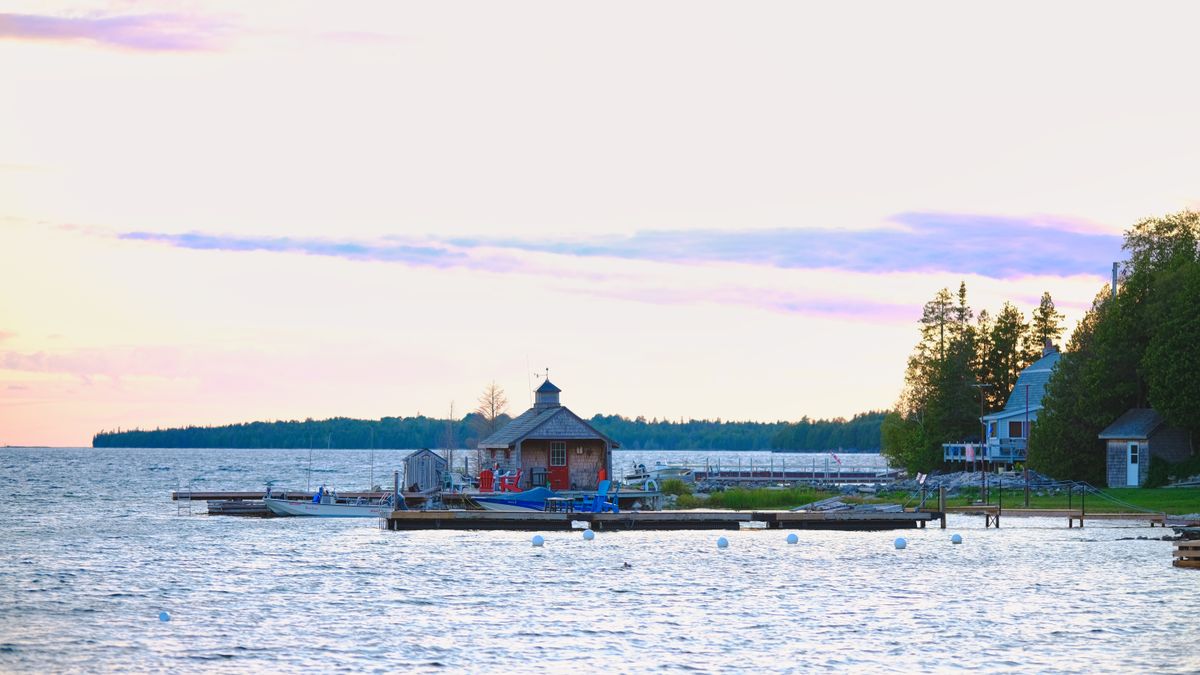 Calm sunset over a lake with a pier and moored boats