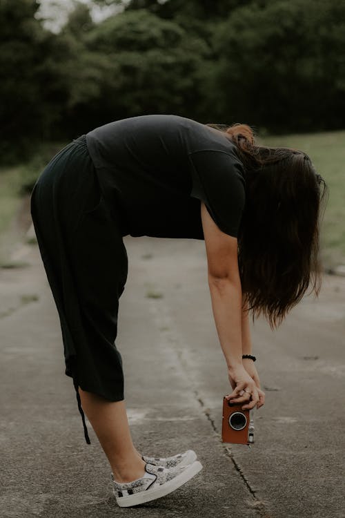 Woman Stretching and Bending with Camera in Park