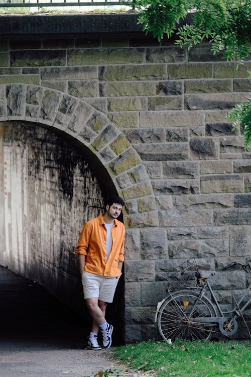 Foto profissional grátis de bicicleta, camisa laranja, fotografia de moda