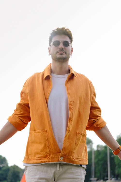 Portrait of Man Standing in Orange Shirt and Sunglasses