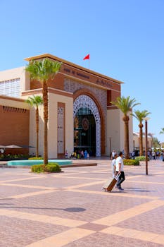 Vibrant scene of Marrakesh railway station and palm-lined square on a sunny day.