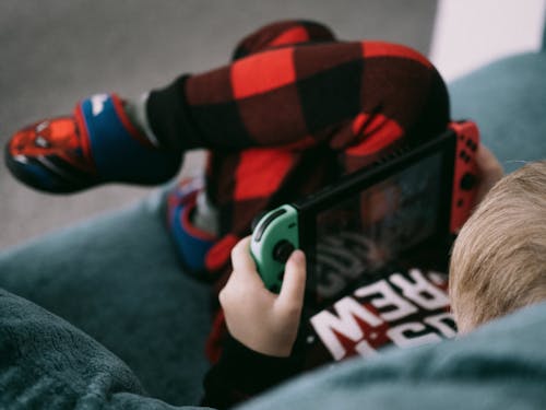 Boy Sitting on a Couch and Playing a Video Game 
