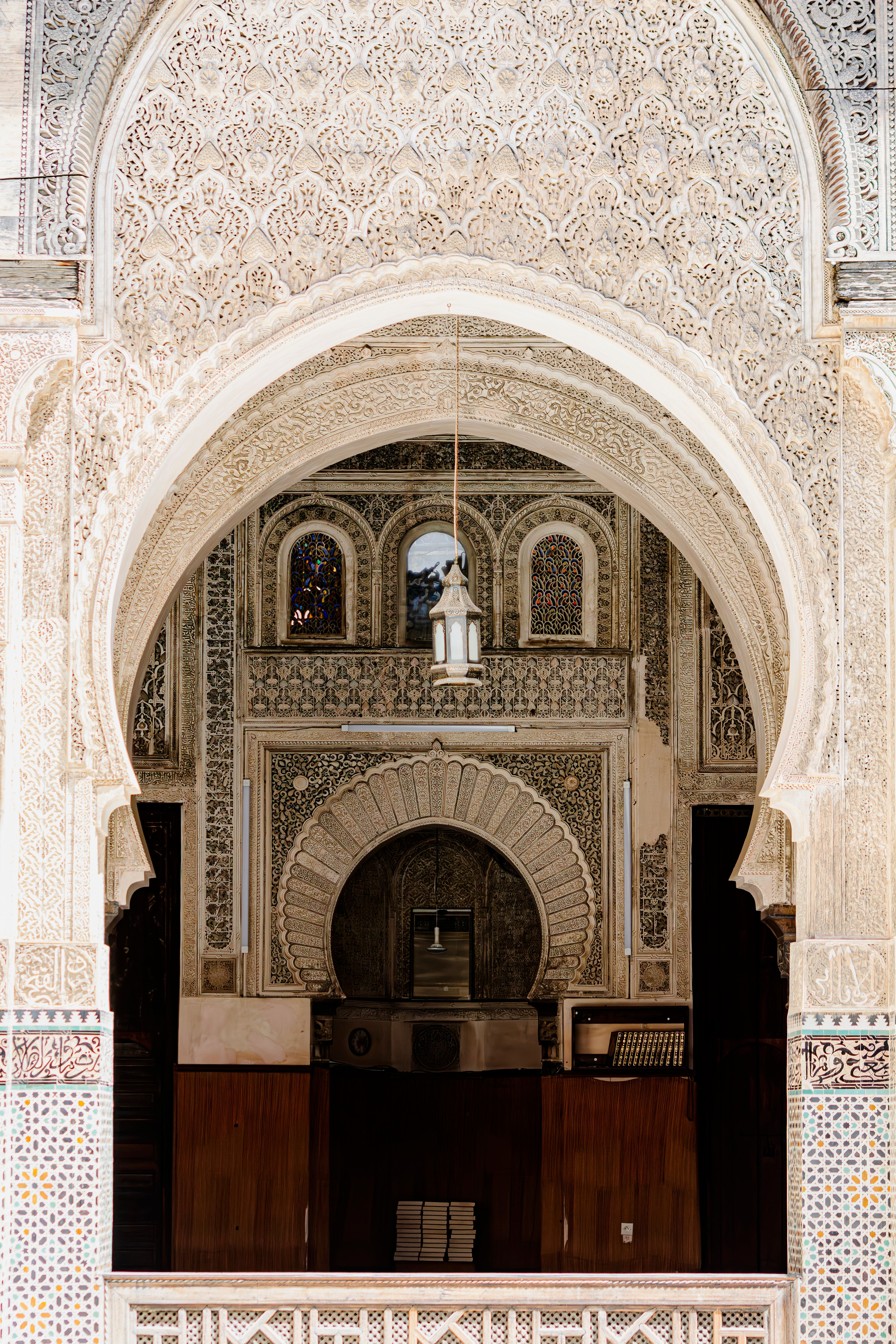 The intricate Islamic geometric tilework and historical arches of a traditional madrasa in Morocco for a multi city Umrah stopover holiday