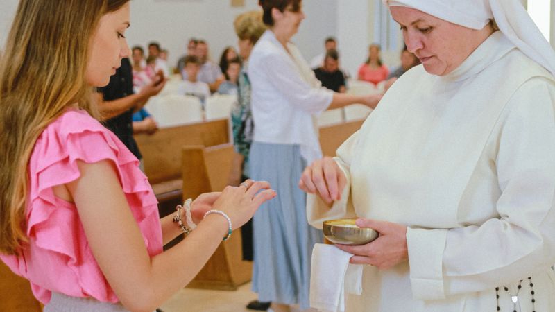 A communion ceremony with a nun inside a church, featuring participants in spiritual reflection.