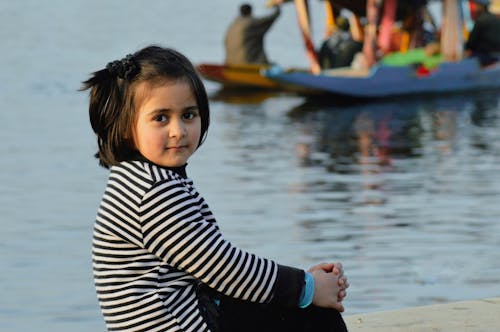 Little Girl Sitting by the Water