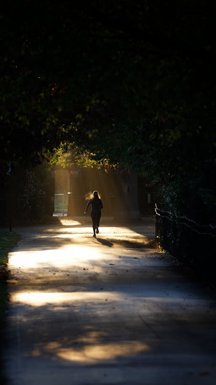 Woman Running in Sunlit Alley