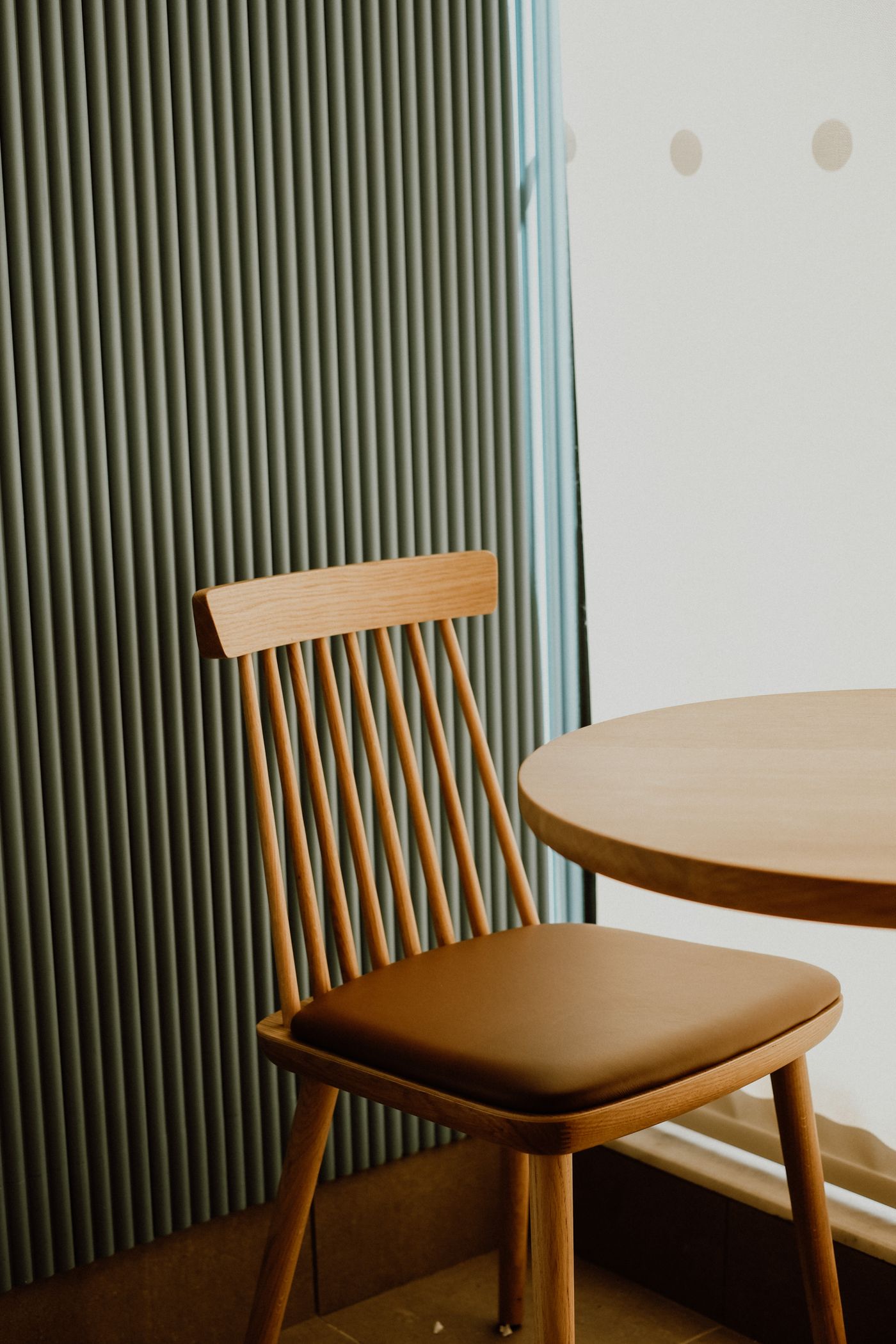 Silla y mesa de madera junto a una ventana, rincón del taller