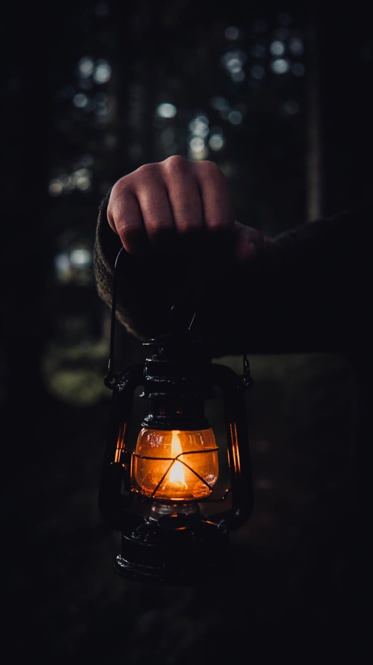 Hand Holding Vintage Lantern In Darkness