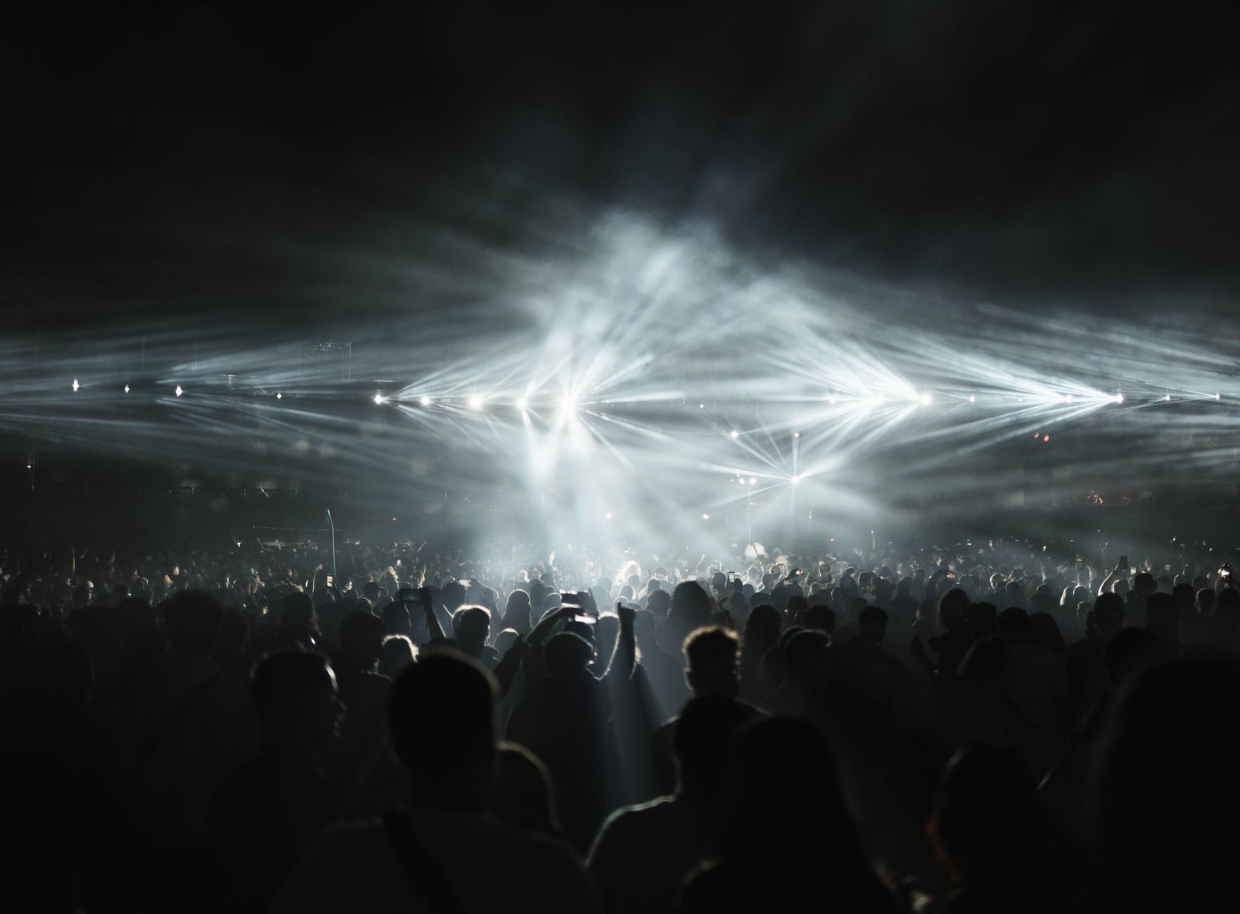 Bas ağırlıklı elektronik müzik çalan bir konserde dans eden kalabalık