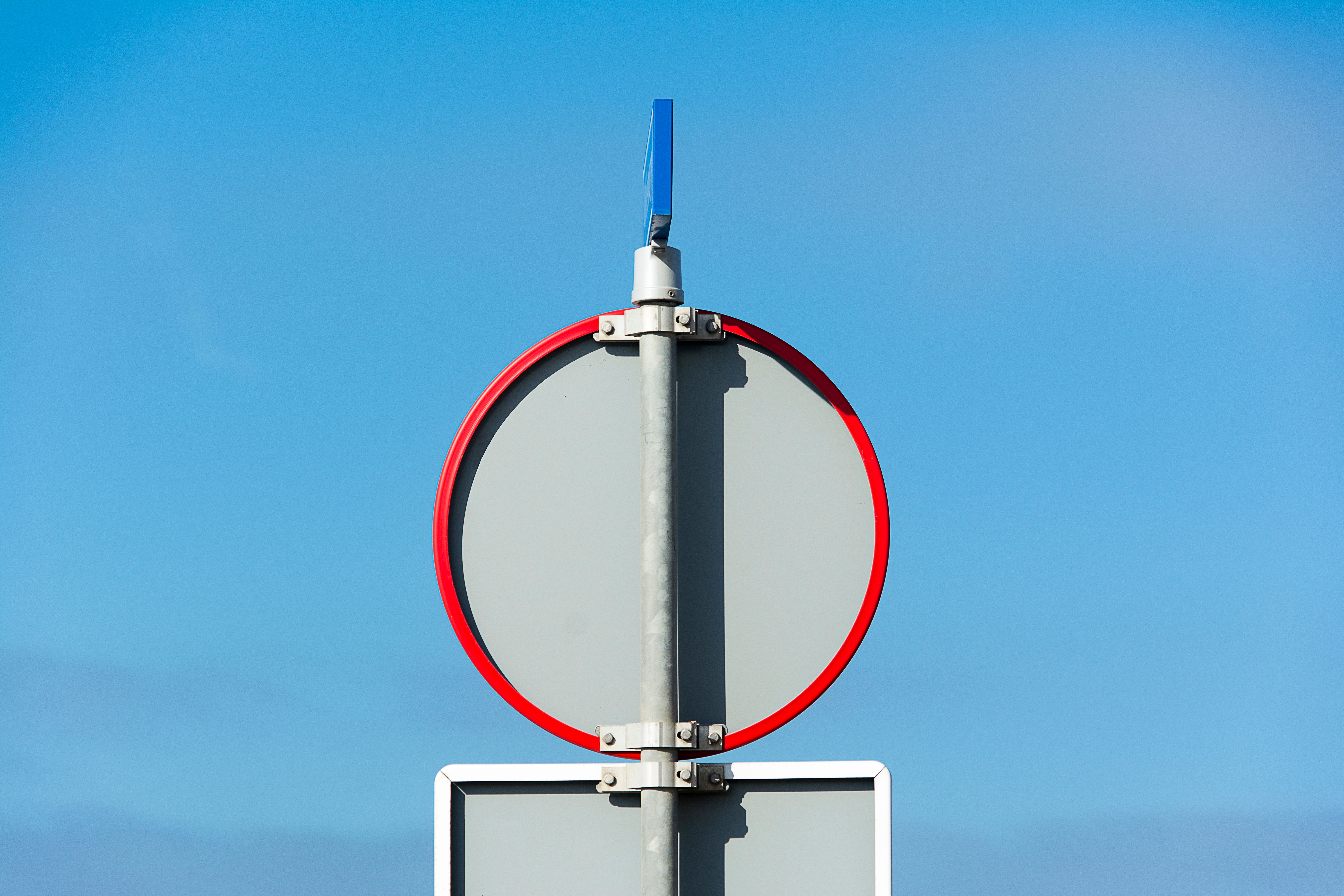 A blank traffic sign against a clear blue sky, perfect for various contexts.