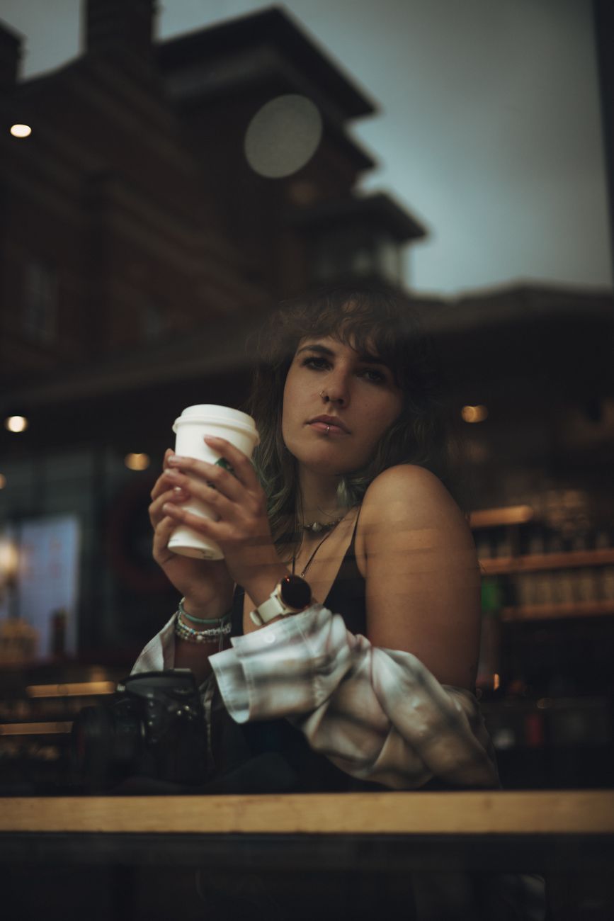 Woman with Disposable Coffee Cup on the Other Side of the Cafe Window