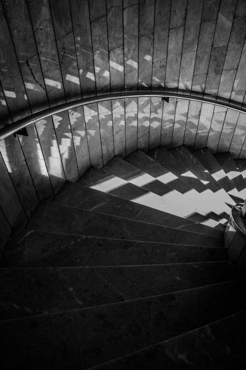 Free Black and white photo of geometric shadows on stone spiral staircase. Stock Photo