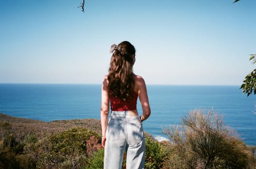 Young Brunette in Jeans Looking at Ocean