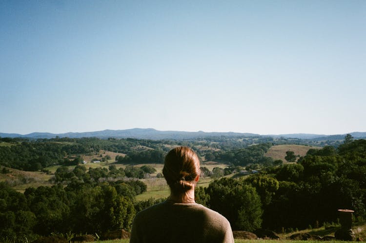 Person Looking At A Rolling Landscape From A Hill