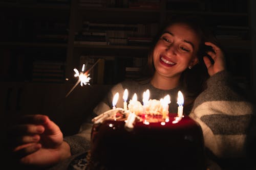 Smiling Woman with Sparkler and Birthday Cake at Night