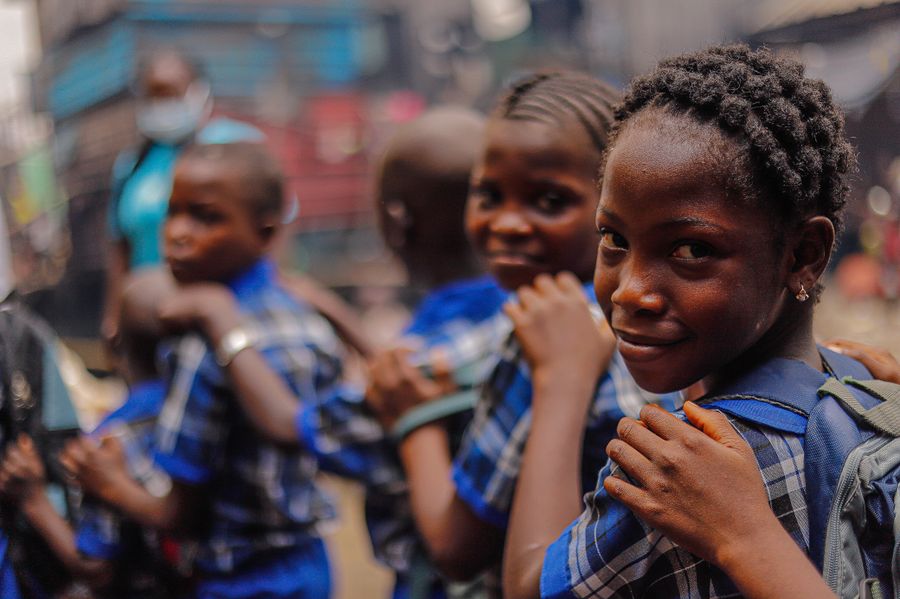 Cheerful children in school uniforms standing outdoors