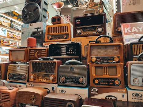 A variety of retro and vintage radios stacked in an indoor store, showcasing nostalgia.