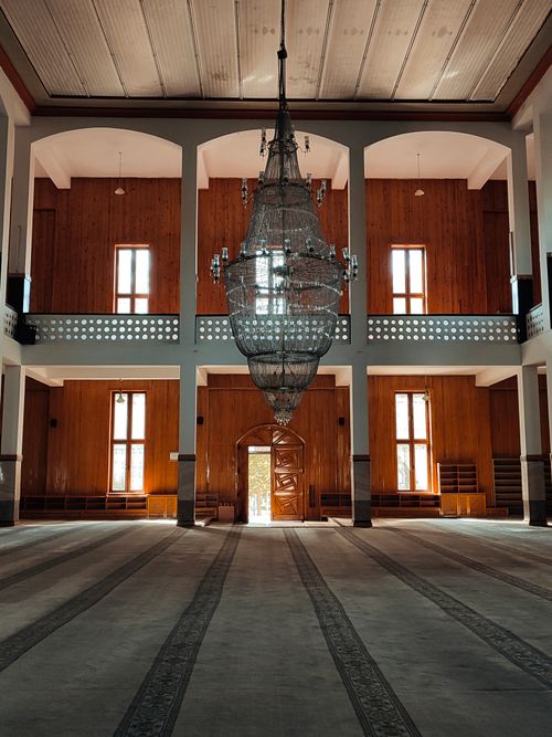 Free Expansive mosque interior featuring a striking large chandelier and serene atmosphere. Stock Photo
