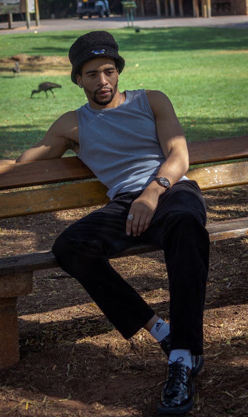 Young Man Sitting on a Bench in a Park 