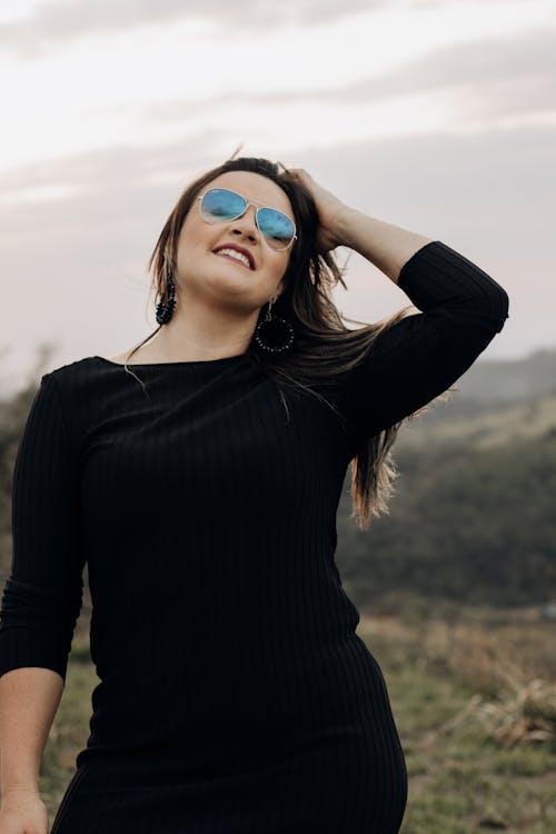 Woman in Sunglasses Fixing Hair